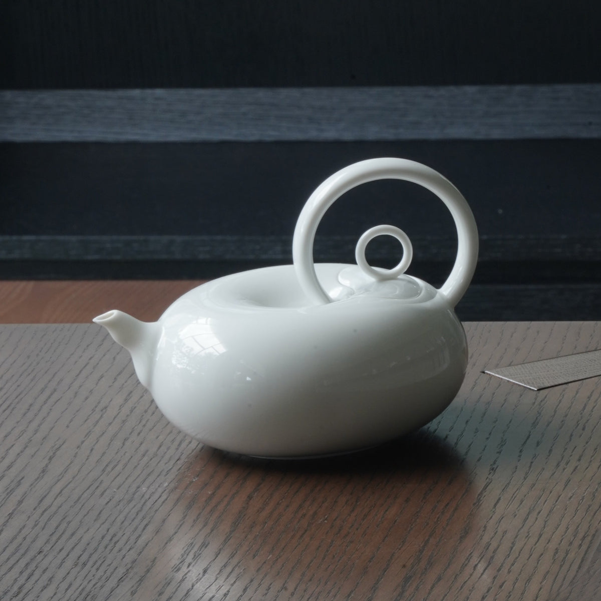 圓好夢白瓷茶壺側面特寫,渾圓壺身、短壺嘴與高揚環形把手清楚可見
