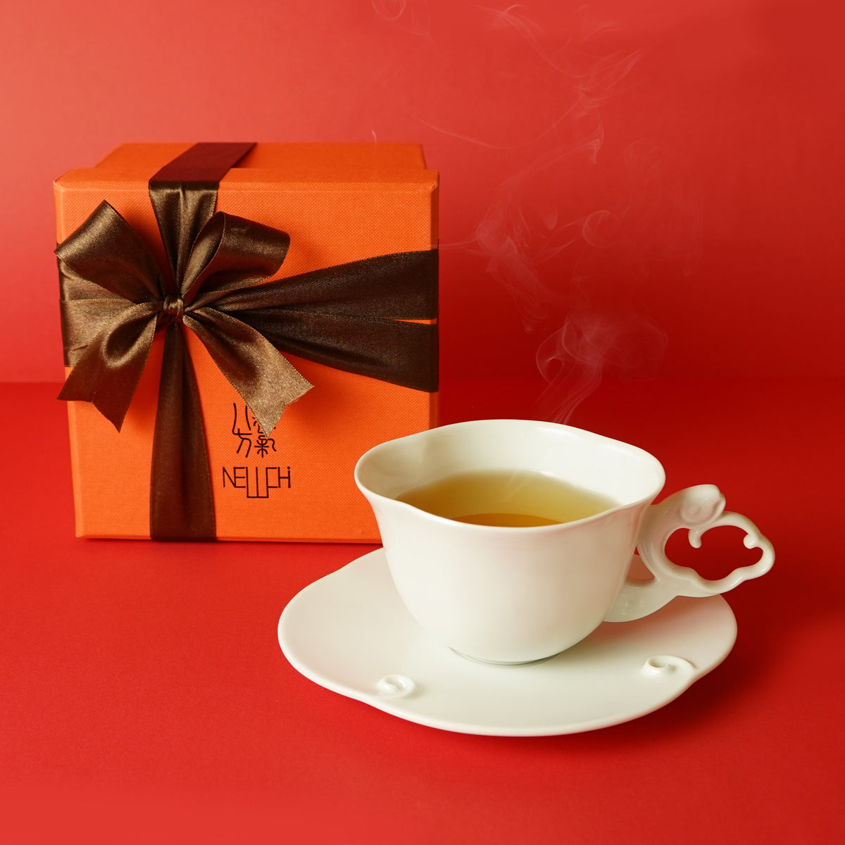 〈與海共舞〉杯盤與熱茶,旁有橘色禮盒