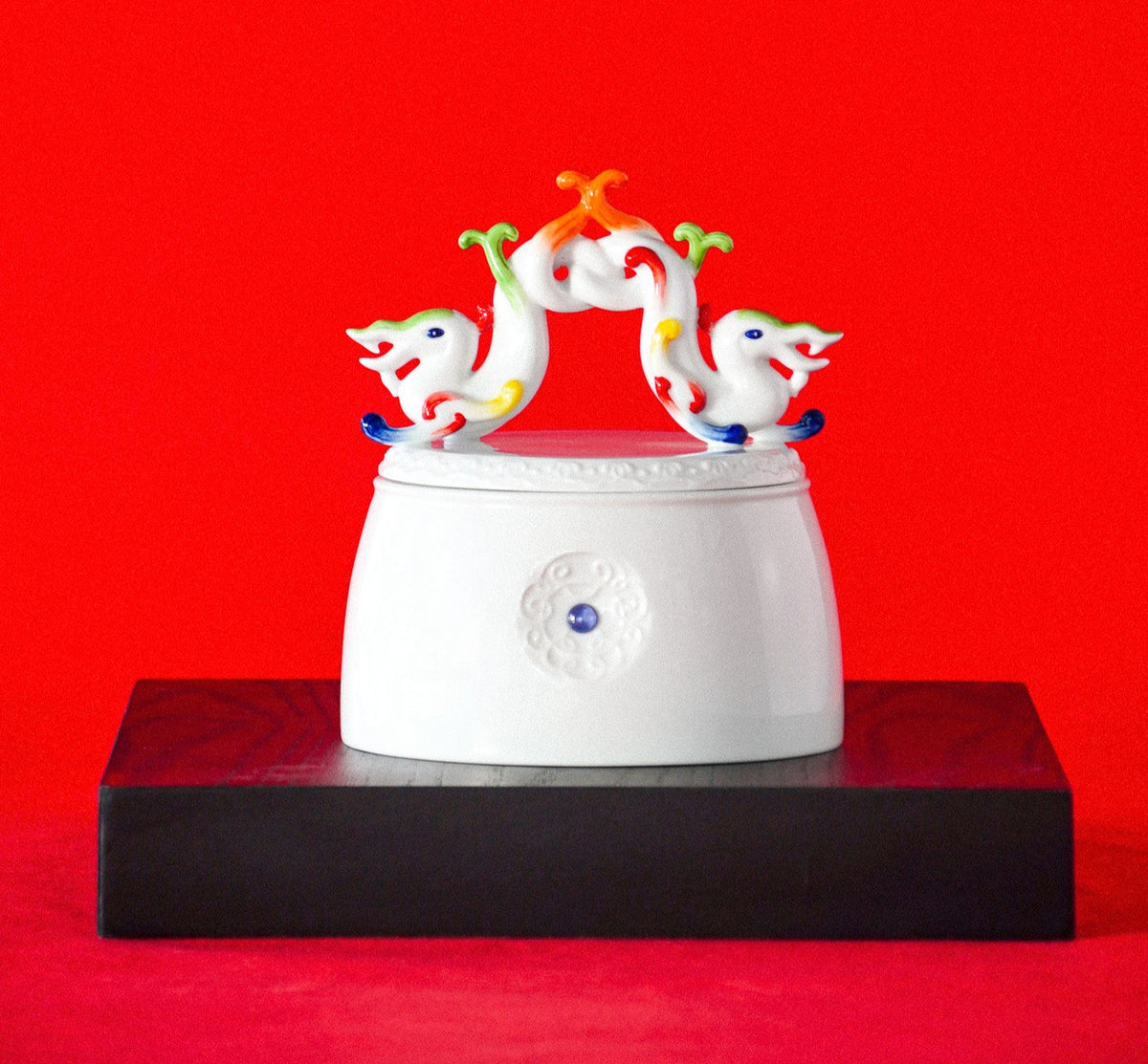 白瓷雙龍環繞瓷盒作品彩繪妝點,象徵喜氣與友誼的雙喜福鎮擺件