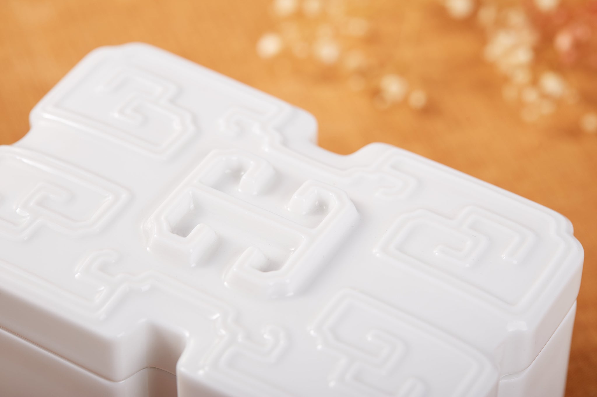 壽字圖騰瓷盒細節特寫—精雕細琢的紋飾象徵長壽安康與綿延福氣
Longevity symbol carving detail — intricately sculpted porcelain texture representing blessings, longevity, and enduring good fortune