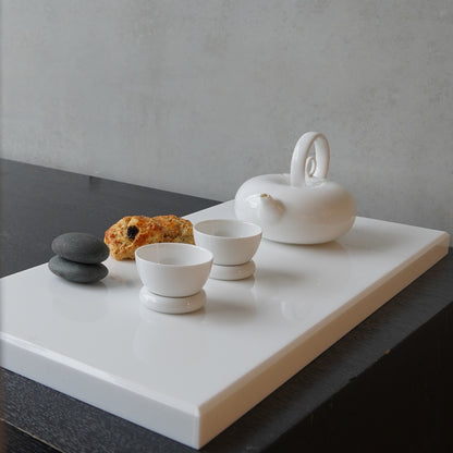 圓好夢白瓷茶壺與茶杯置於白色展示台，呈現現代茶席陳列