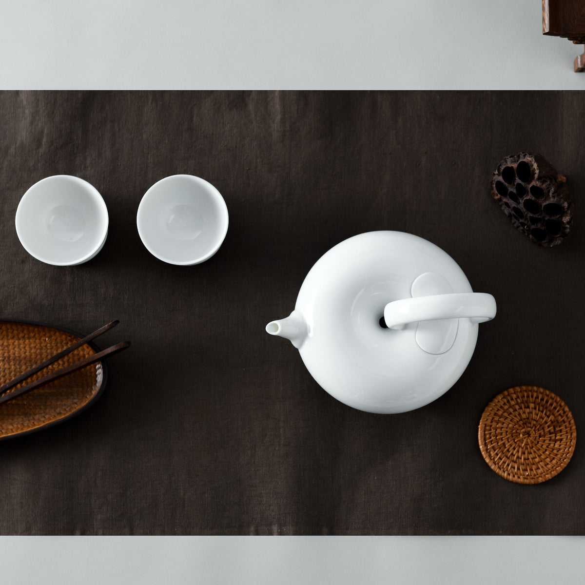 圓好夢白瓷茶具深色茶席俯視圖，茶壺、雙杯與竹製茶席配件整齊排列