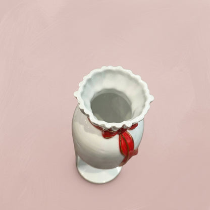 〈精彩連連〉彩頭瓶白瓷藝術品俯視特寫，展現花瓣狀瓶口與頸部紅色金邊蝴蝶結細節