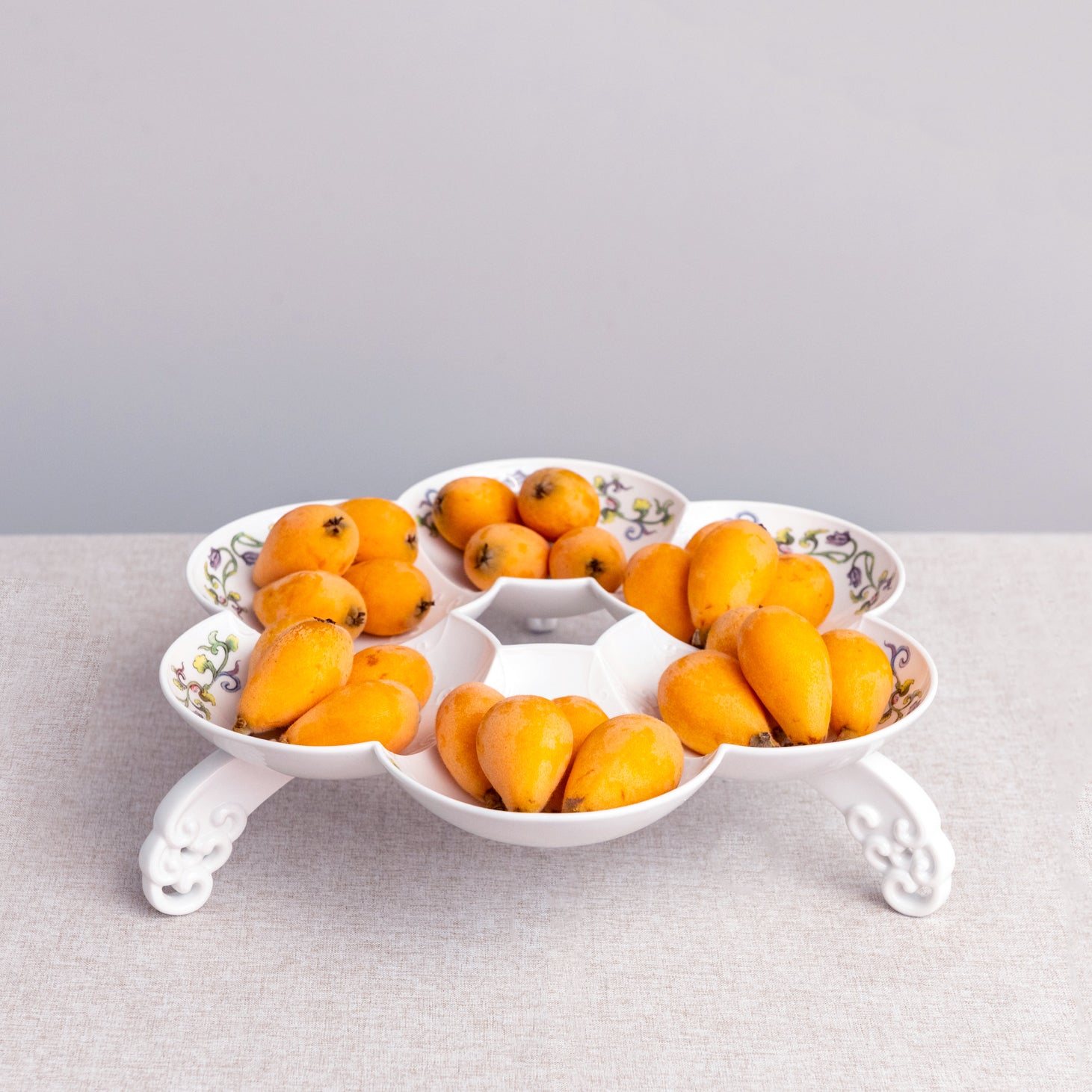 白瓷水果盤置於現代簡約場景中，展現雲紋與浪花細節。