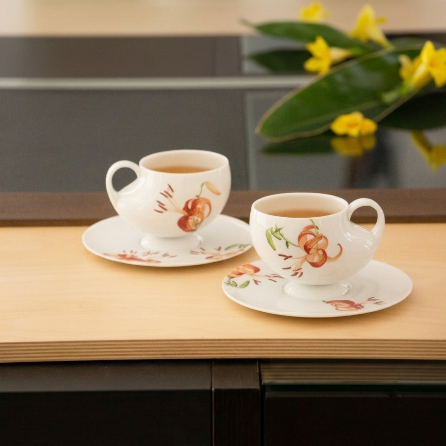 青春 In Bloom 百合白瓷茶壺側面，百合花圖騰隨器型綻放延伸